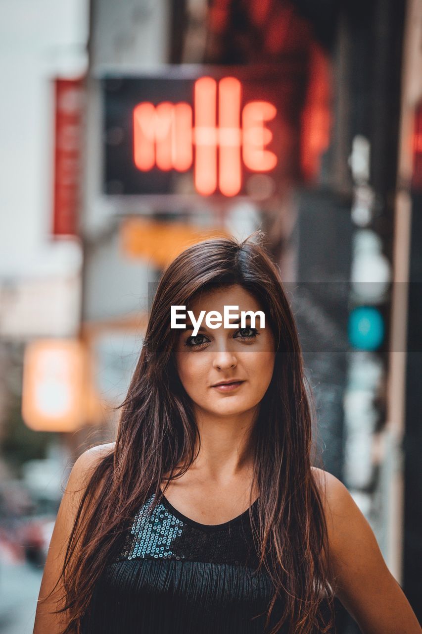 Portrait of beautiful woman standing in city