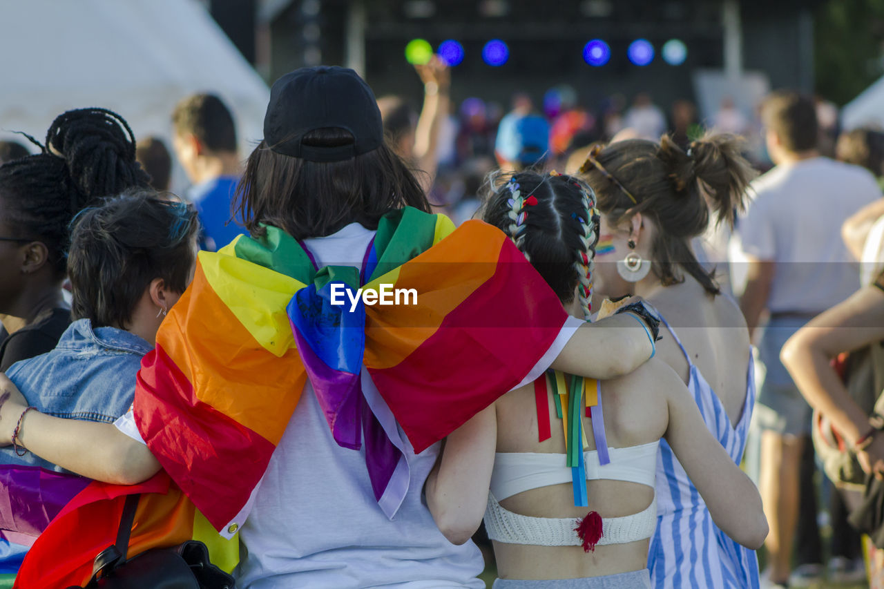 Rear view of women with rainbow flag standing 