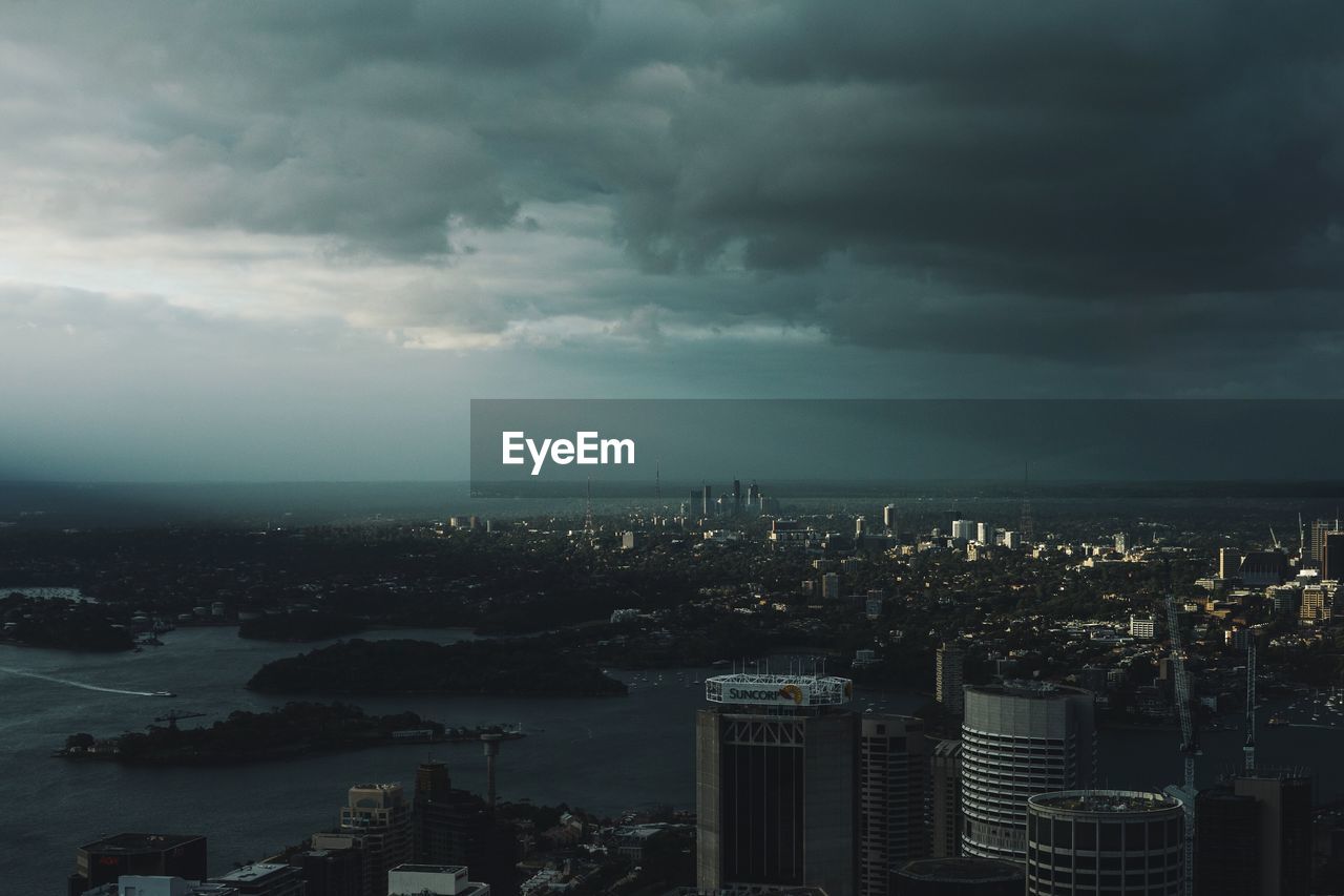 AERIAL VIEW OF CITYSCAPE AGAINST CLOUDY SKY