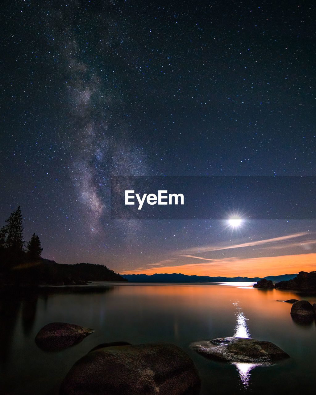 Idyllic view of moon glowing over lake at night