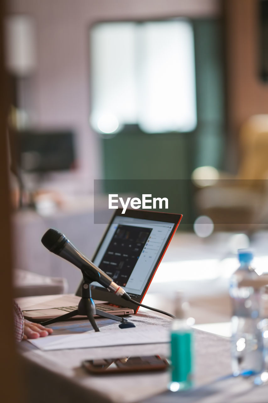 Microphone and laptop on table at business conference