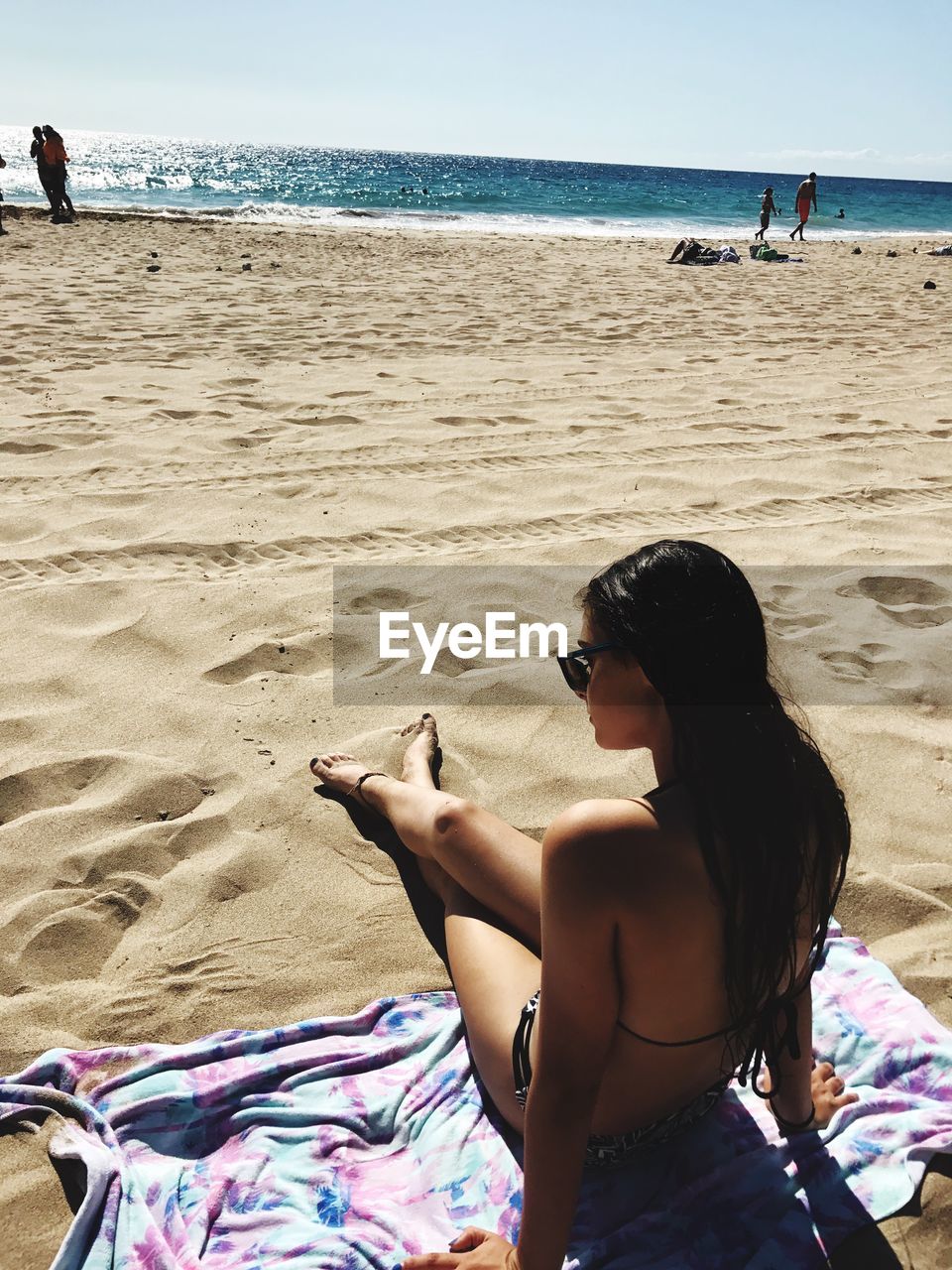 WOMAN SITTING ON BEACH