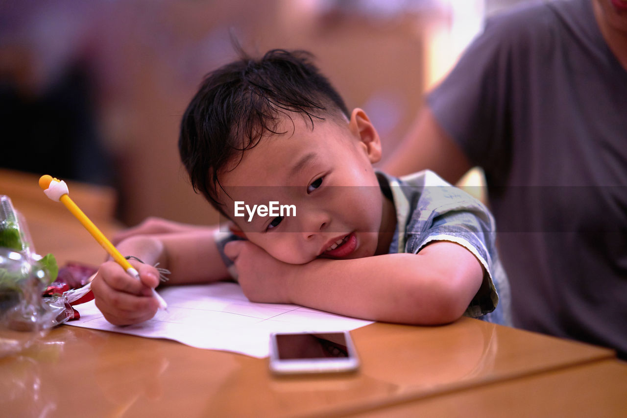 Close-up of boy writing on paper