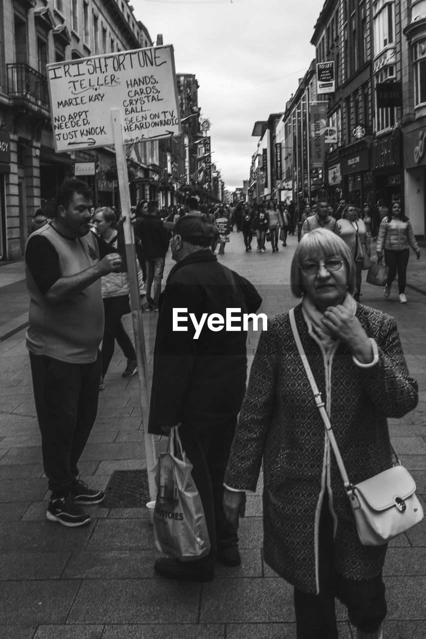 GROUP OF PEOPLE WALKING ON STREET