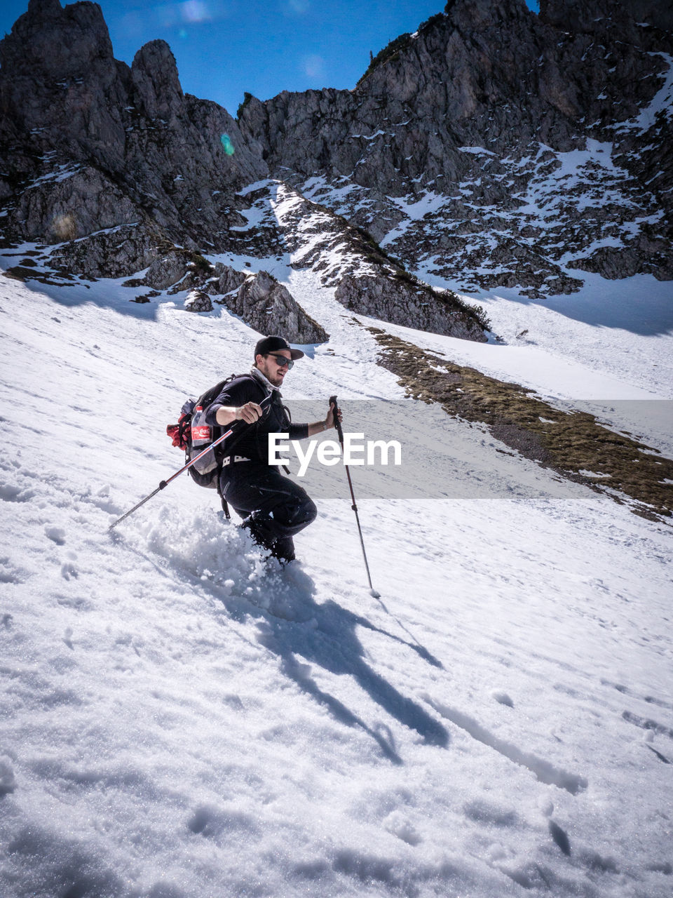 MAN SKIING ON SNOW COVERED LANDSCAPE
