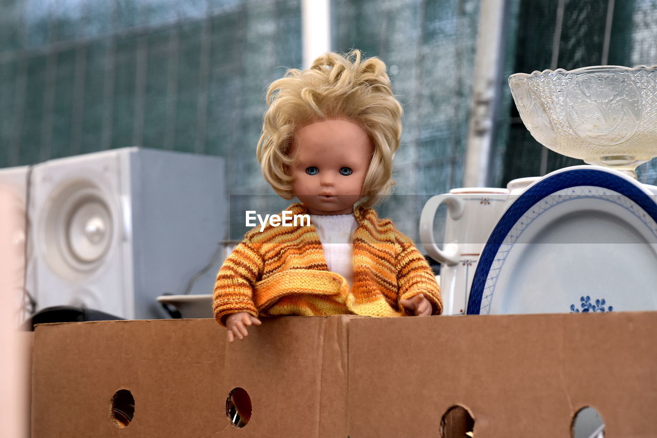 Close-up of doll with kitchen utensils in box