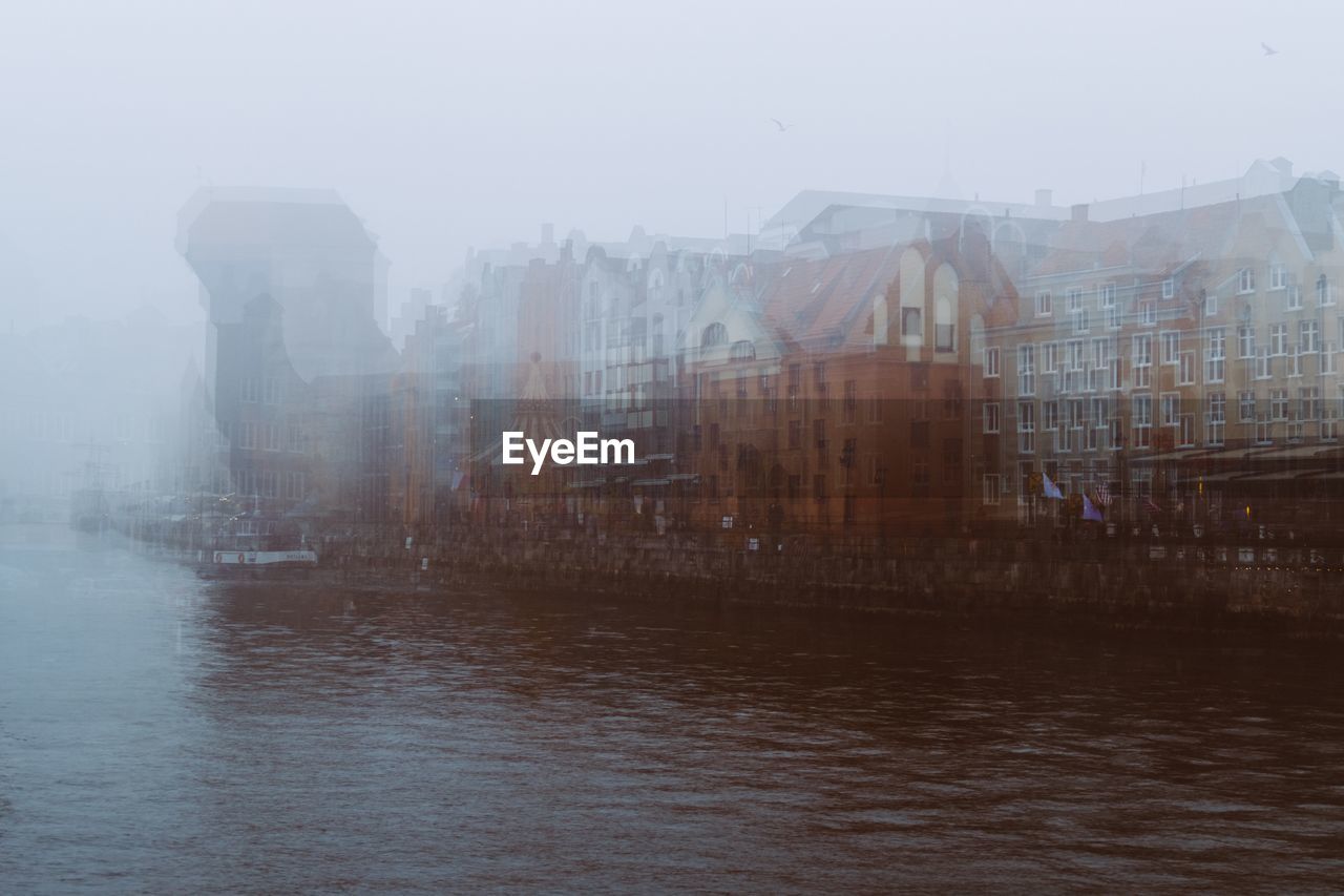 Digital composite image of buildings and river in city