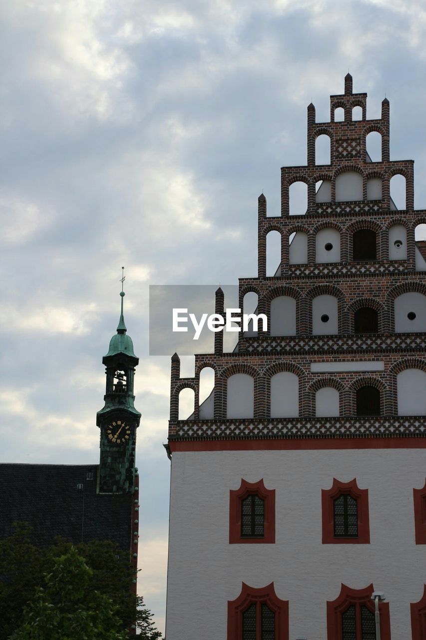 CLOCK TOWER AGAINST CLOUDY SKY