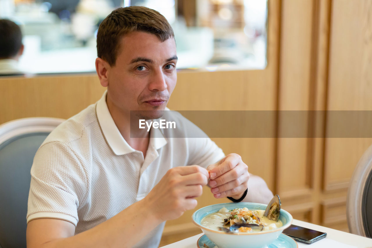 Portrait of young man sitting on table