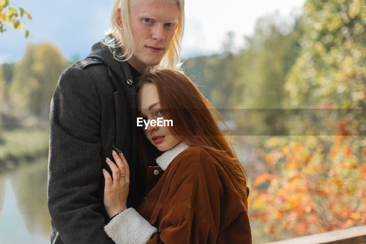 Portrait of couple standing in park during autumn