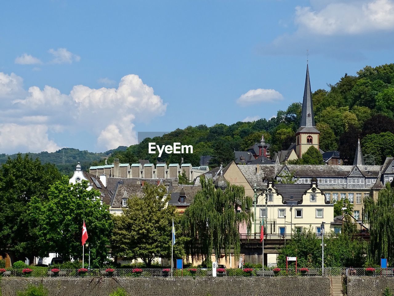 Panoramic view of buildings and trees on the rhine river in germany against blue sky