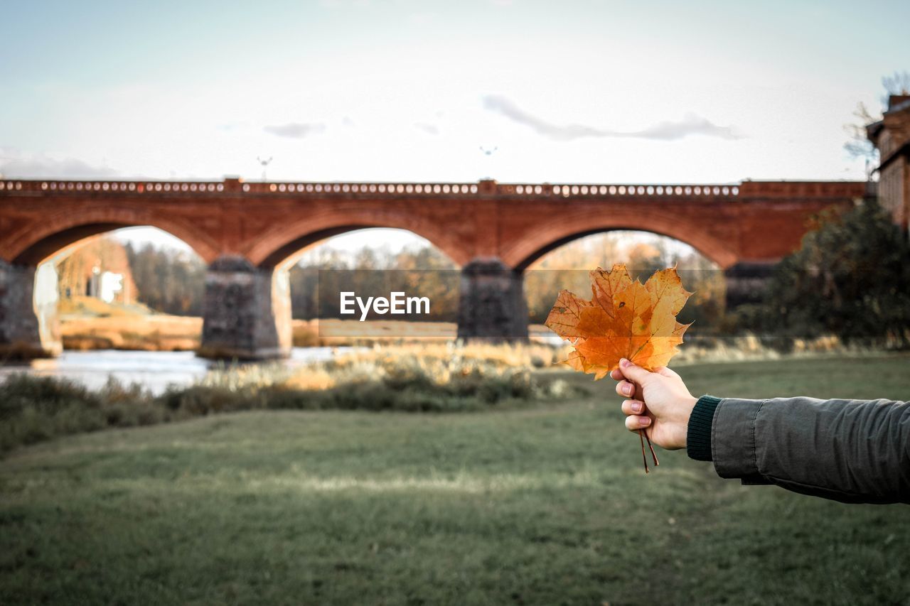 PERSON HOLDING ARCH BRIDGE