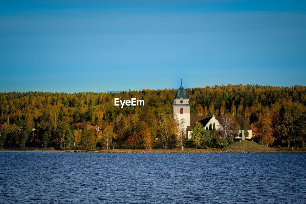 Scenic view of lake by building against sky