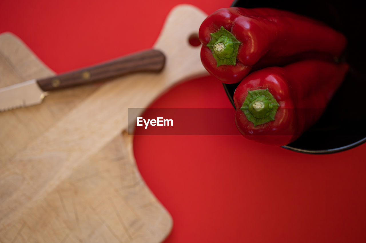 HIGH ANGLE VIEW OF RED CHILI PEPPERS ON CUTTING BOARD