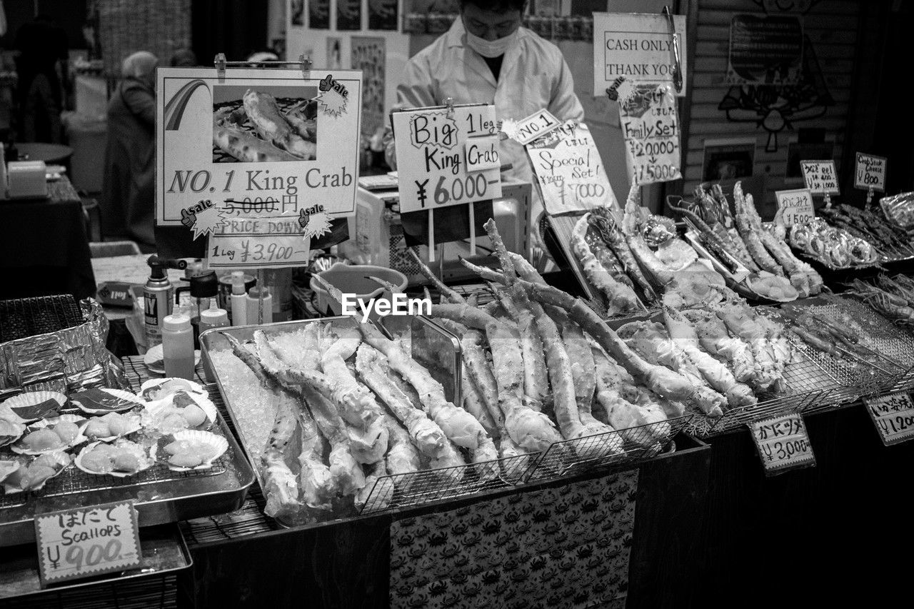 food, food and drink, retail, freshness, market, black and white, for sale, business, market stall, seafood, monochrome, fish, variation, business finance and industry, monochrome photography, occupation, person, healthy eating, men, store, city, text, one person, wellbeing, price tag, fast food, large group of objects, arrangement, abundance, adult, black, animal, small business, communication, selling, clothing, meat