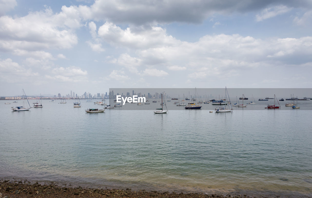 Boats moored in sea against sky