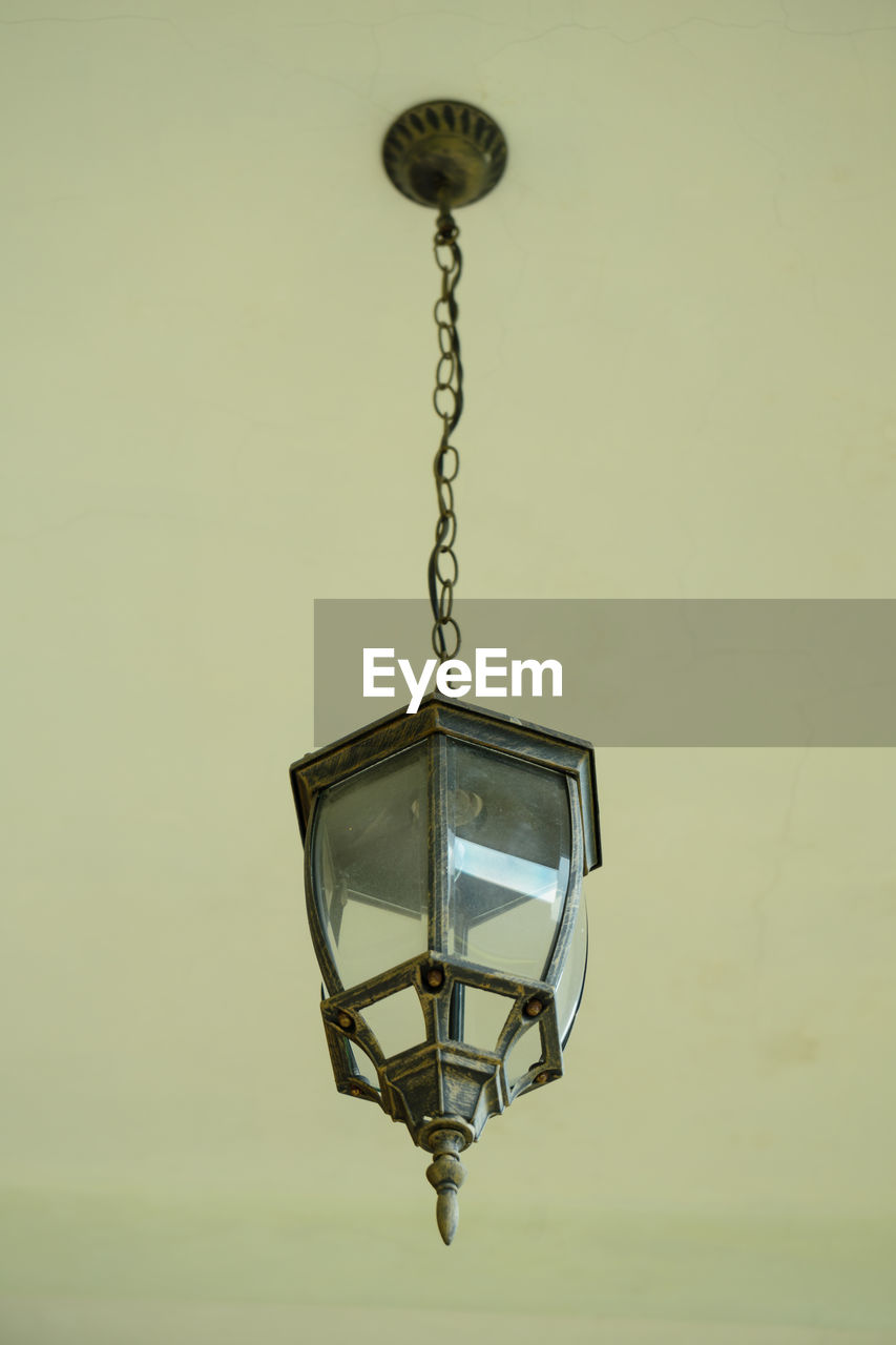ELECTRIC LAMP HANGING AGAINST WALL