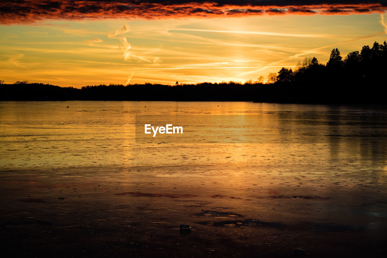 SCENIC VIEW OF LAKE AGAINST ORANGE SKY DURING SUNSET