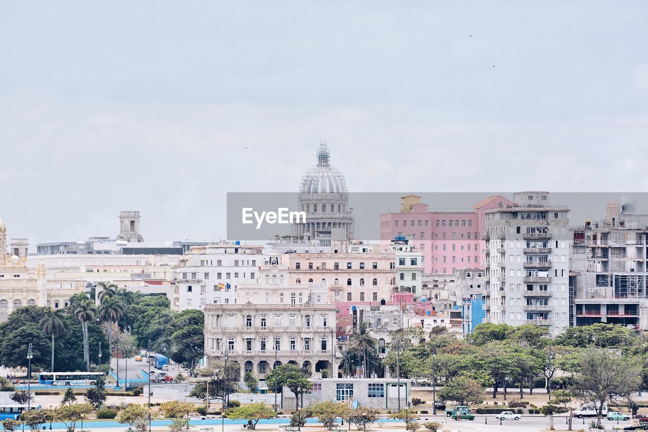 Buildings in city against cloudy sky