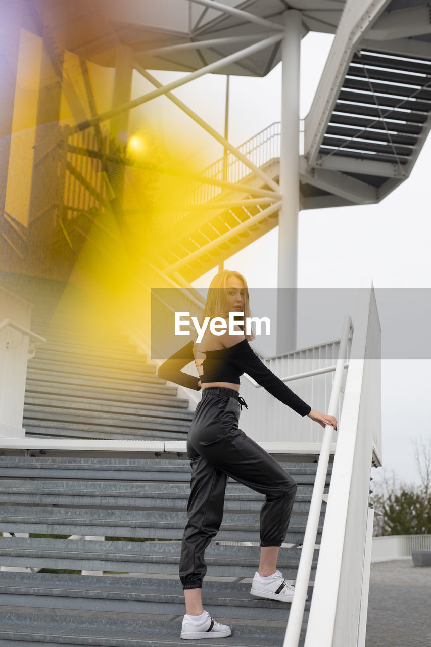 Rear view of woman standing on staircase