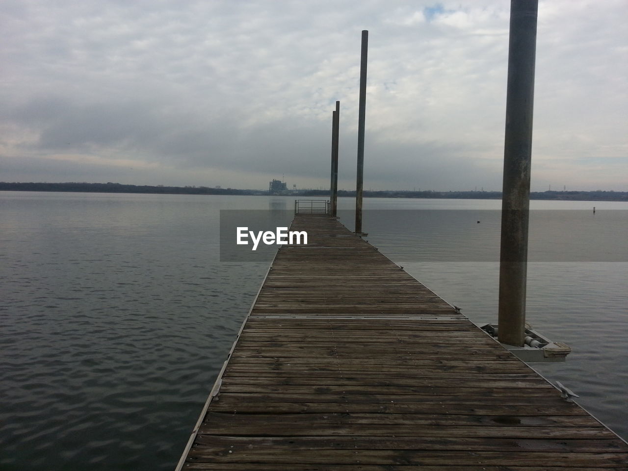 PIER ON SEA AGAINST CLOUDY SKY