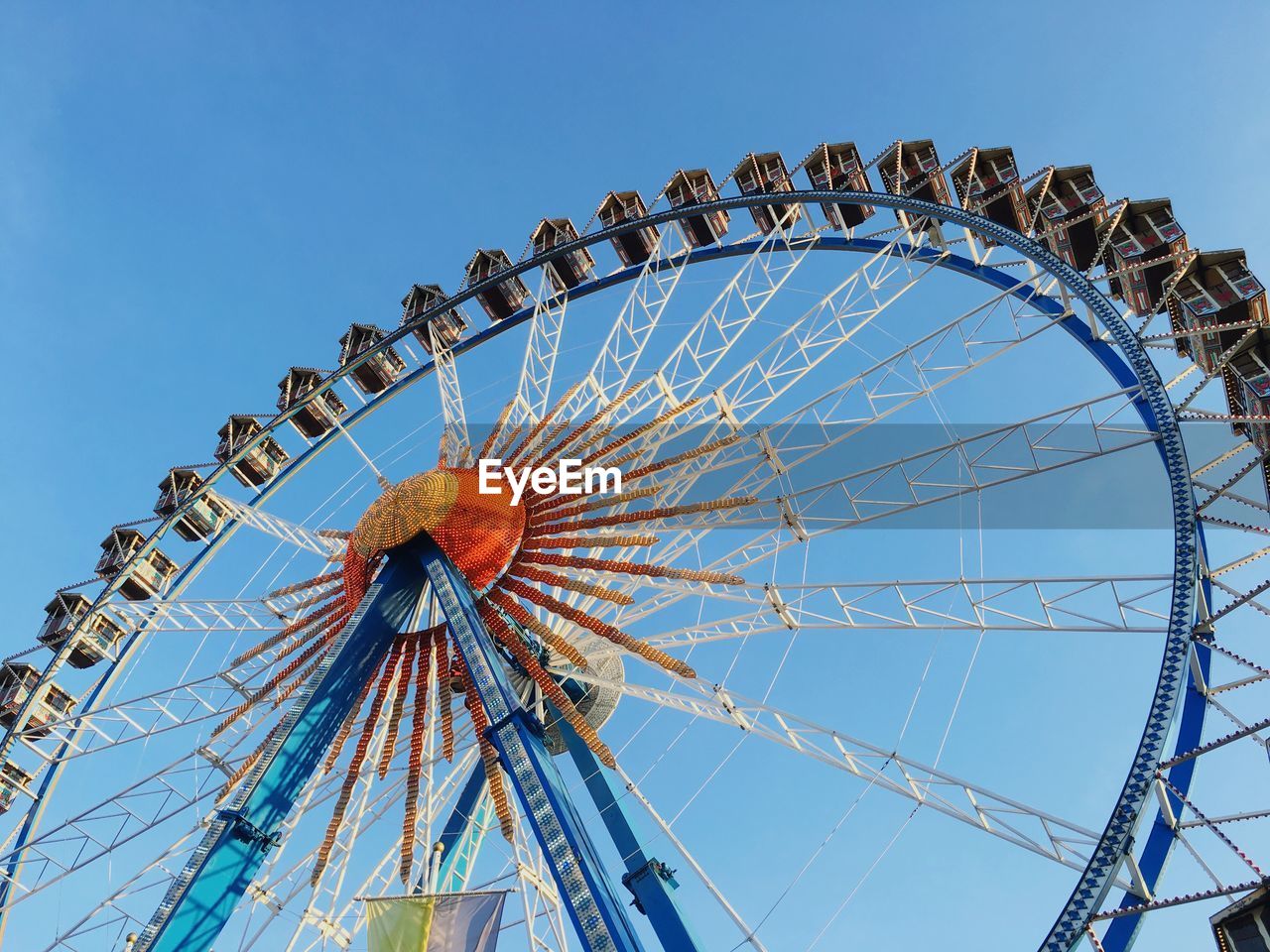 Low angle view of ferris wheel against clear blue sky