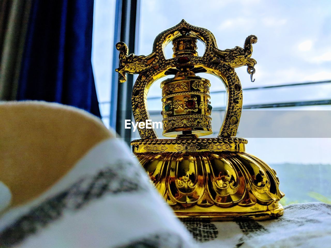 Close-up of prayer wheel on table against window