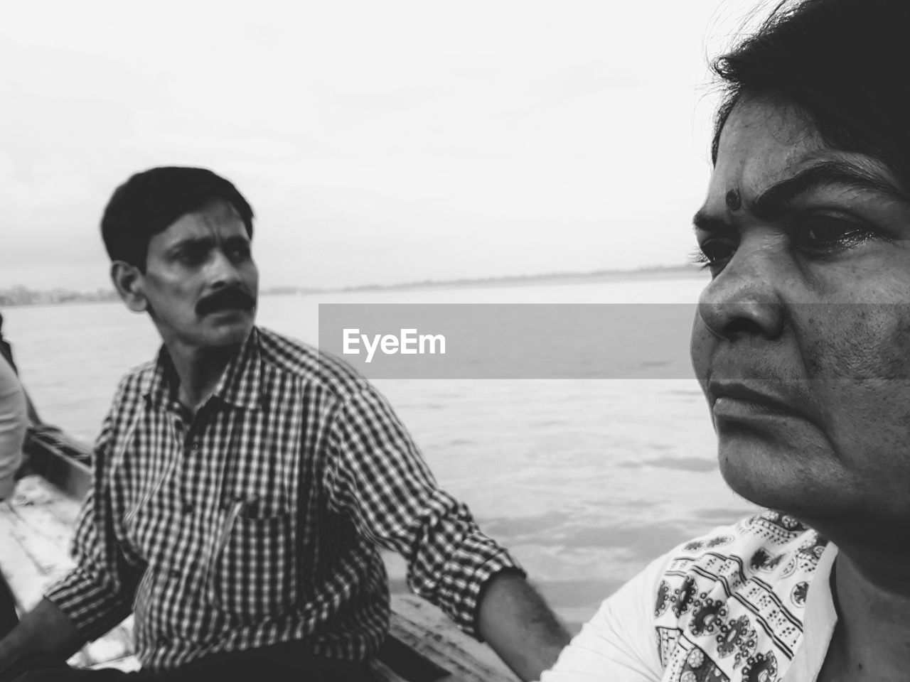 People in boat on lake against sky