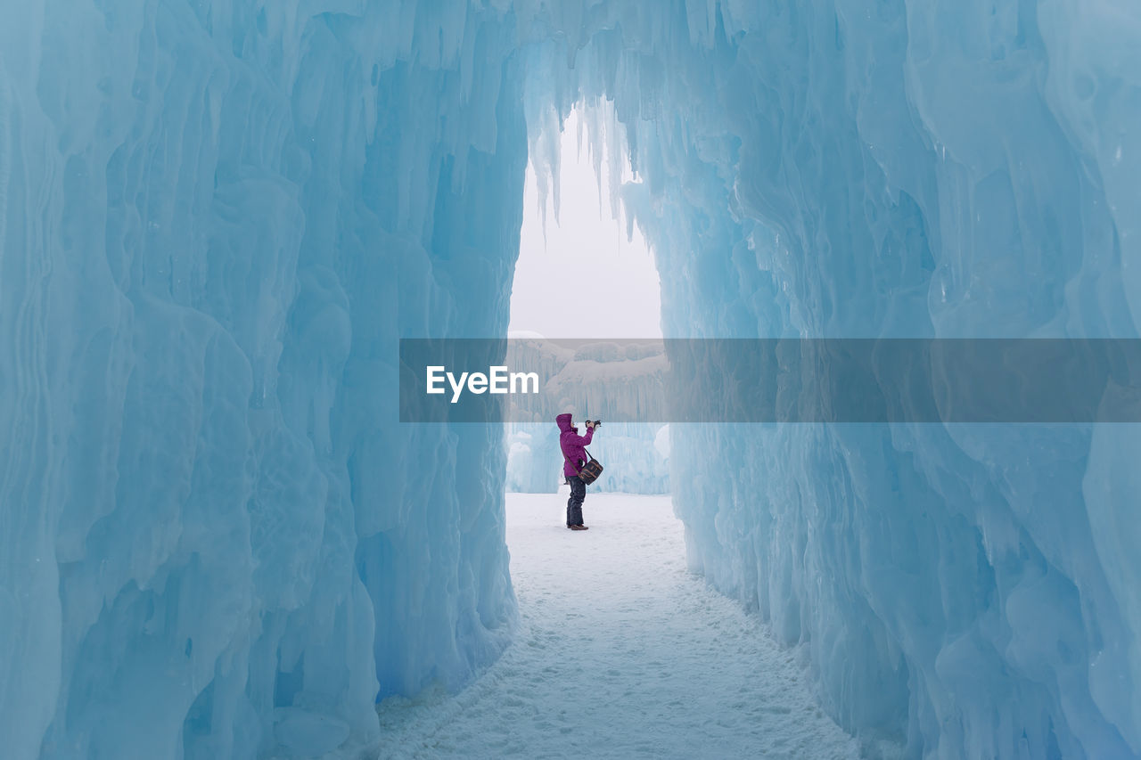 REAR VIEW OF PERSON ON SNOWCAPPED MOUNTAIN