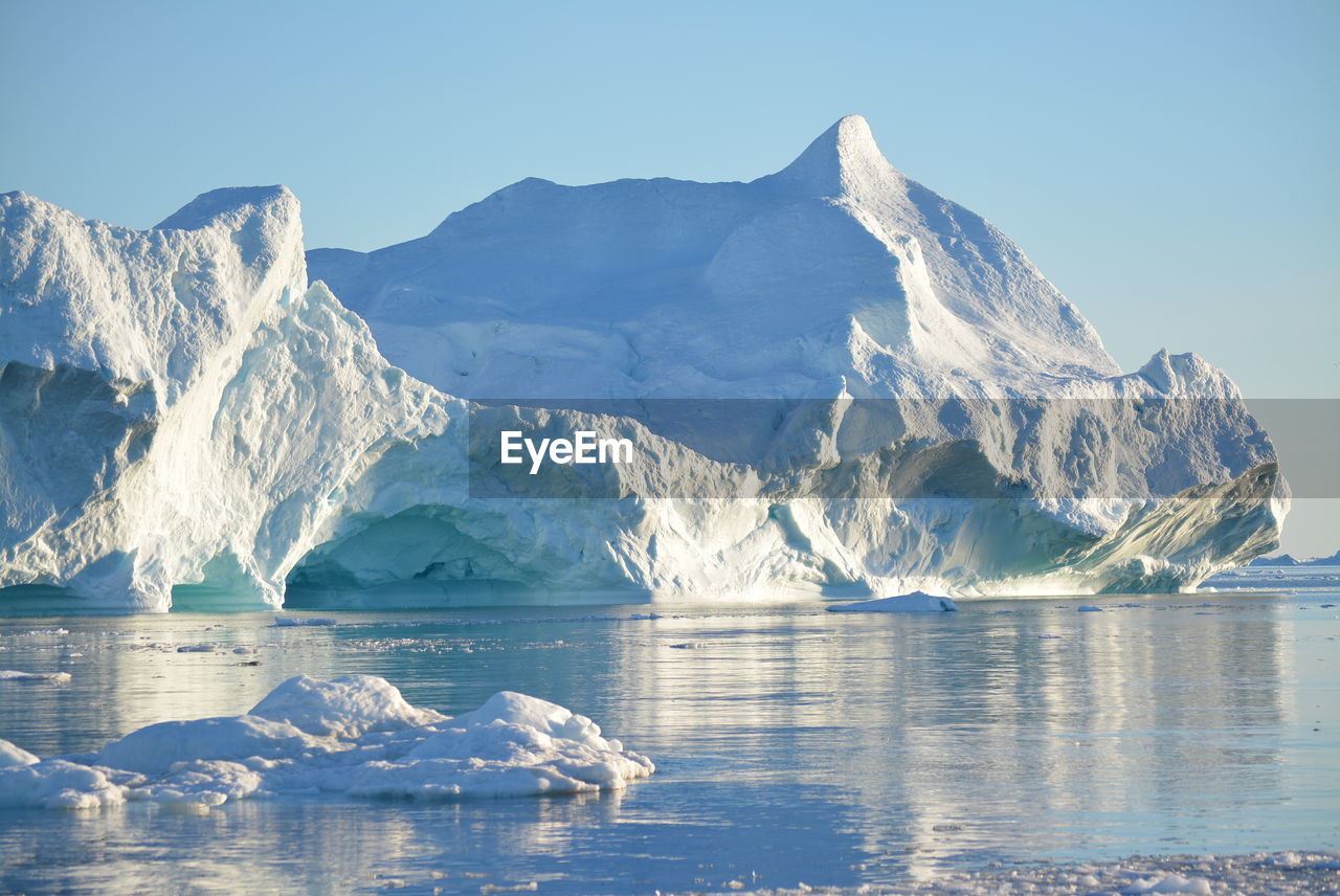 View of majestic iceberg in sea against sky