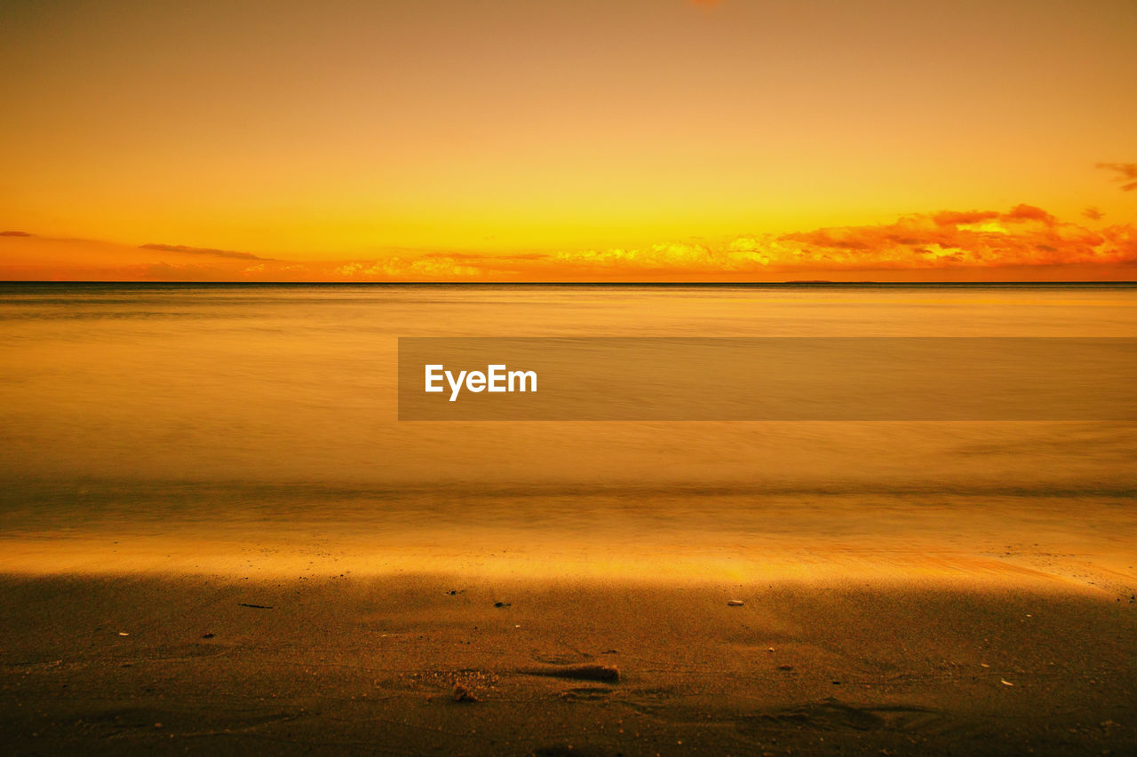 SCENIC VIEW OF BEACH AGAINST SKY DURING SUNSET