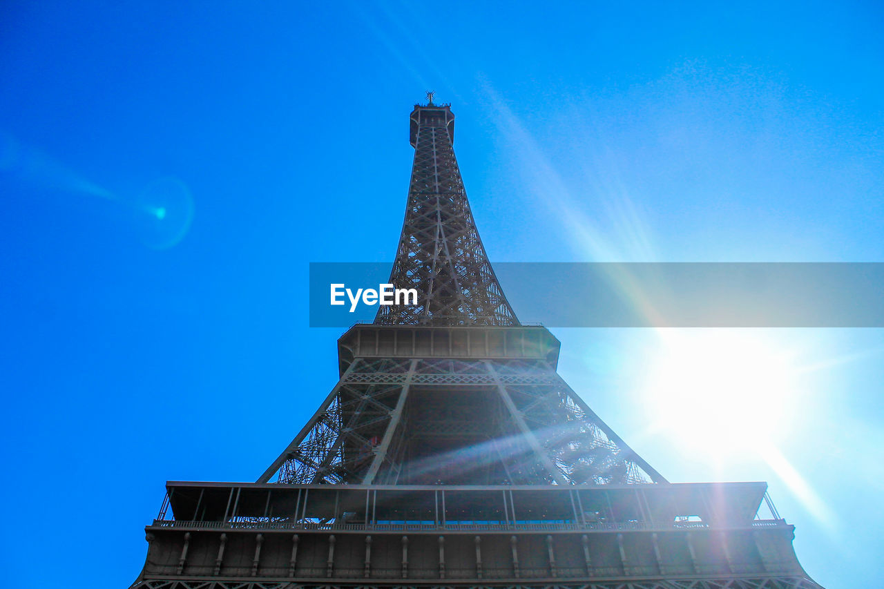 Low angle view of illuminated tower against blue sky