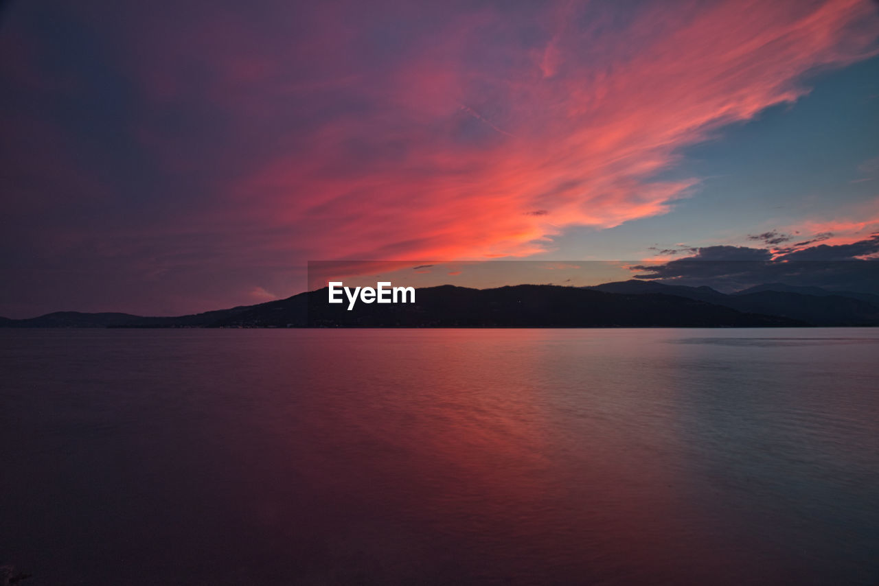 Scenic view of lake against romantic sky at sunset