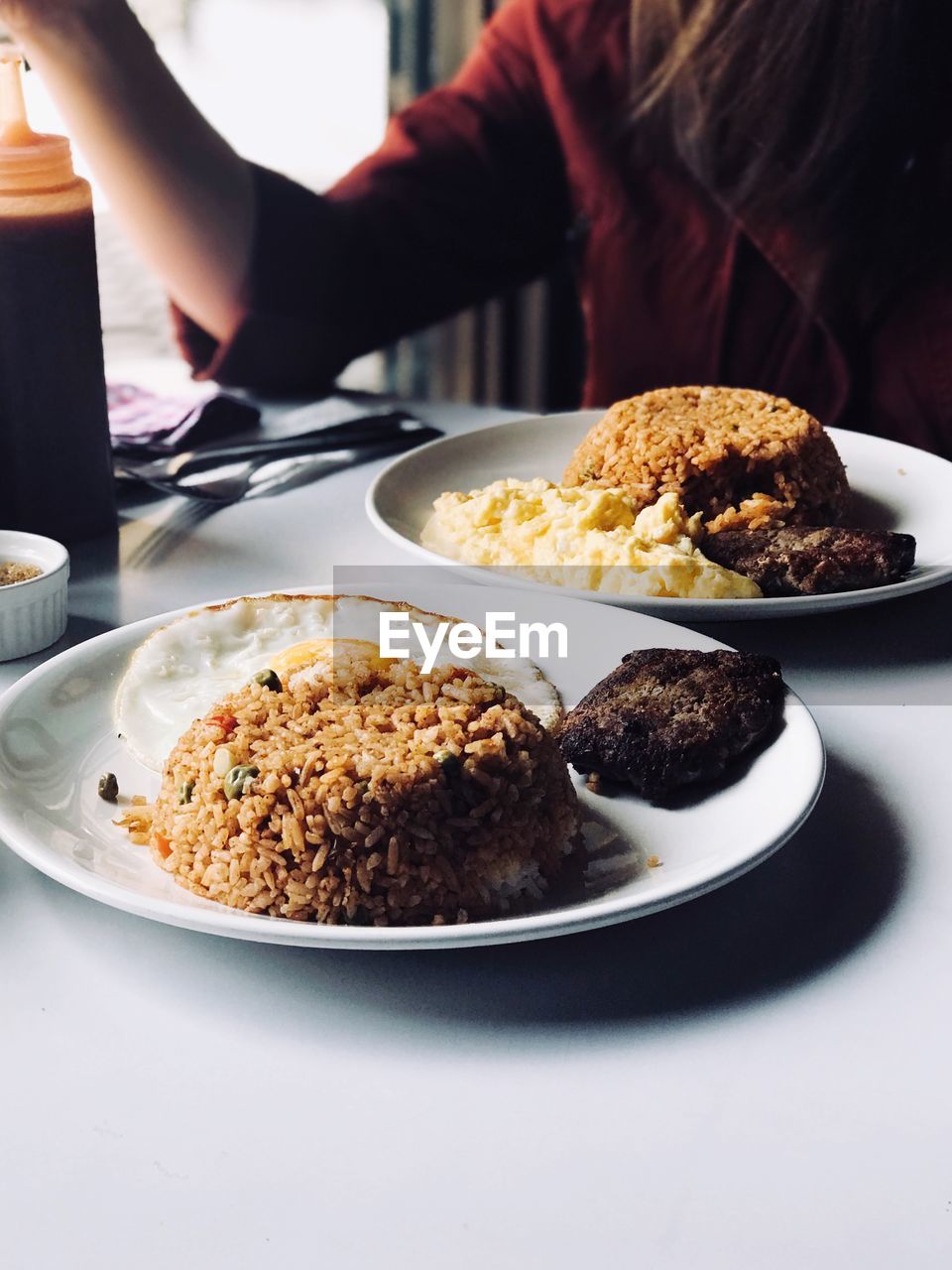 Midsection of woman having food at table in restaurant