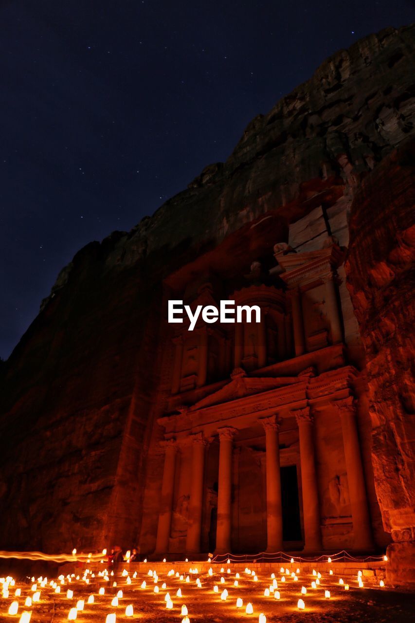 LOW ANGLE VIEW OF ILLUMINATED MOUNTAIN AGAINST SKY