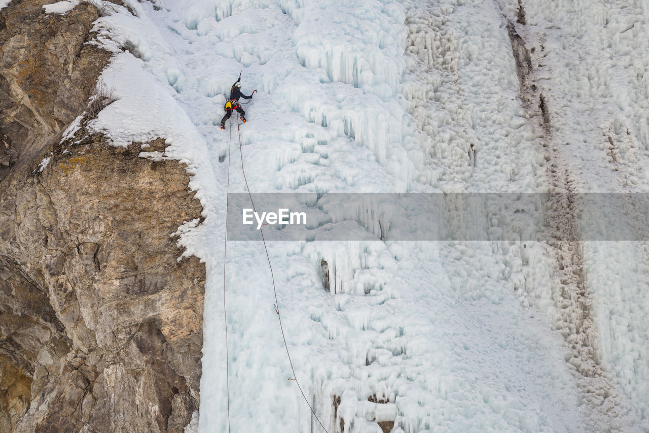 Woman climbs cliff at ice park in lake city, colorado