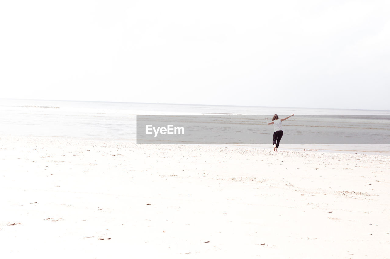 Wide angle of woman running on beach