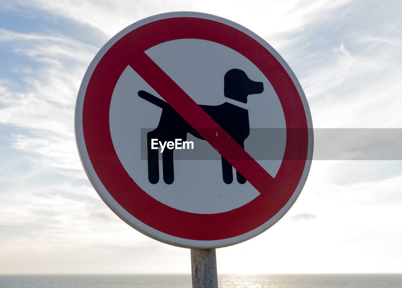 Close-up of road sign against sky