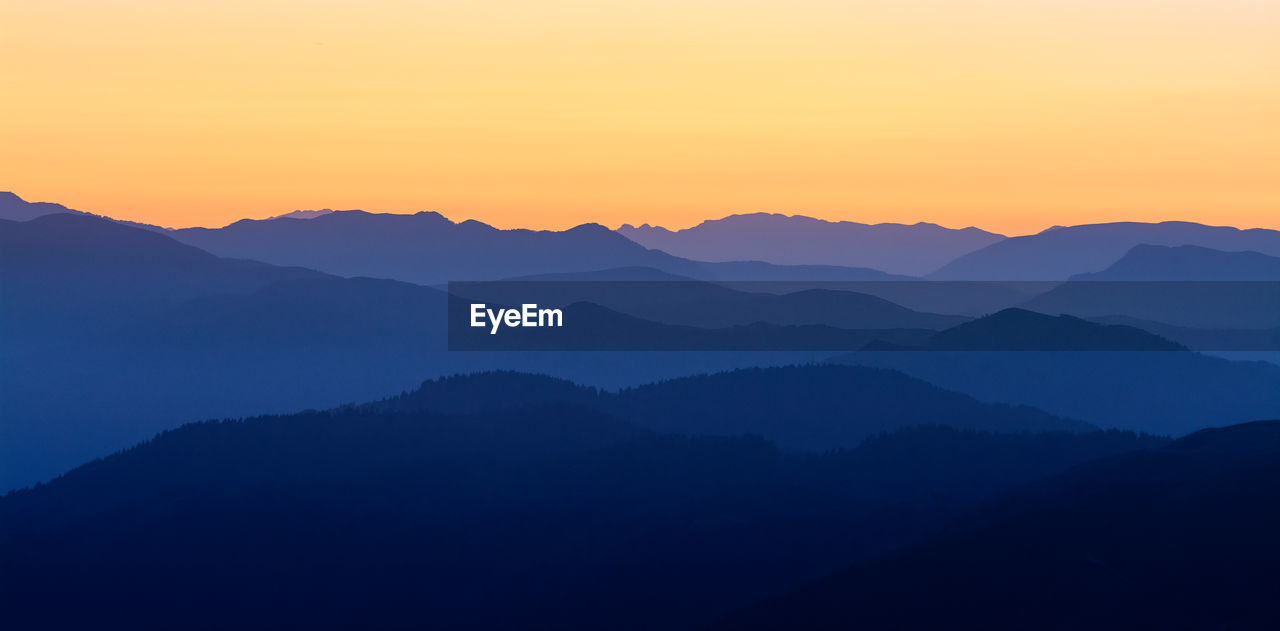 Scenic view of silhouette mountains against sky during sunset