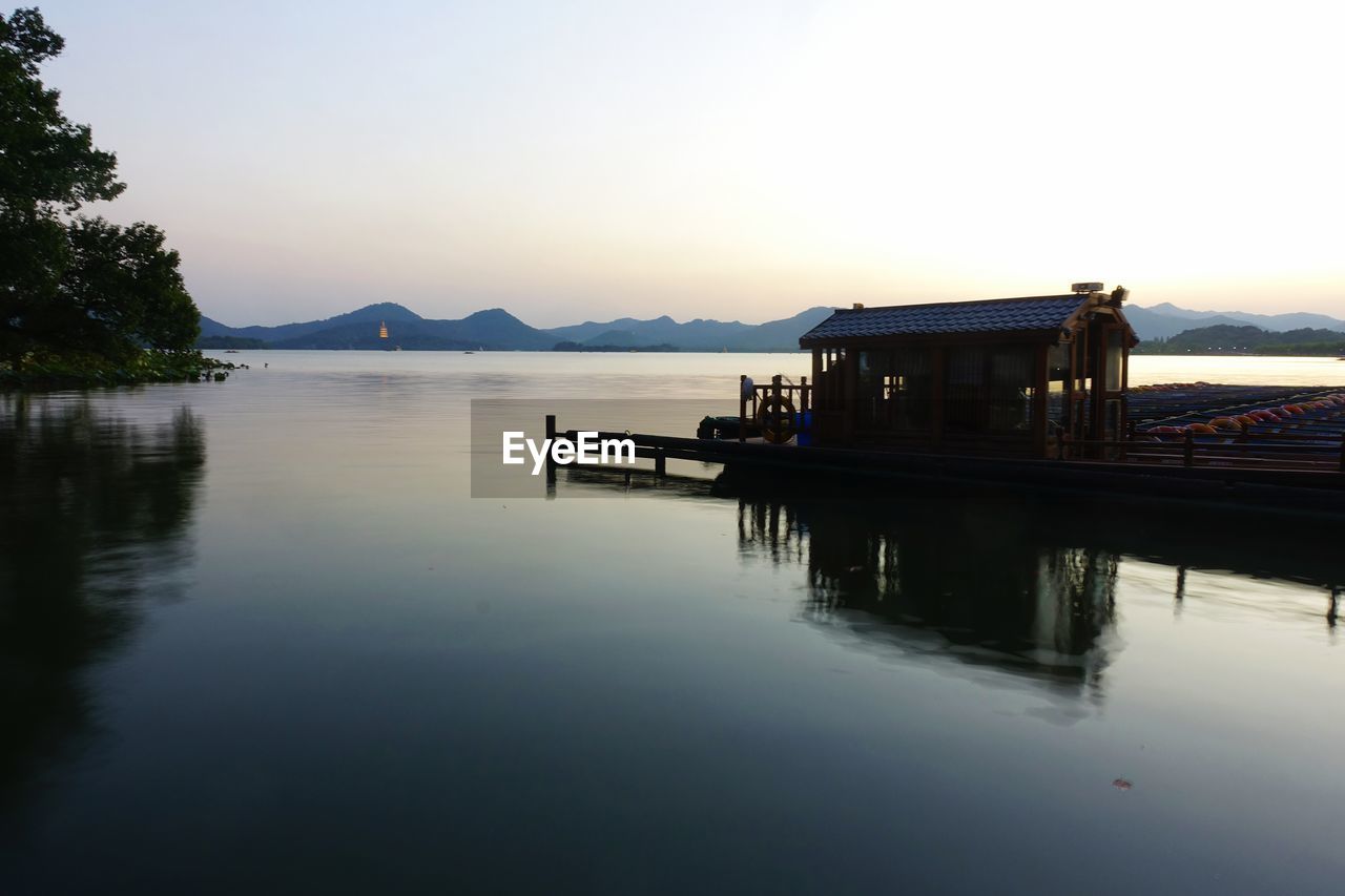 PIER IN LAKE AGAINST SKY DURING SUNSET