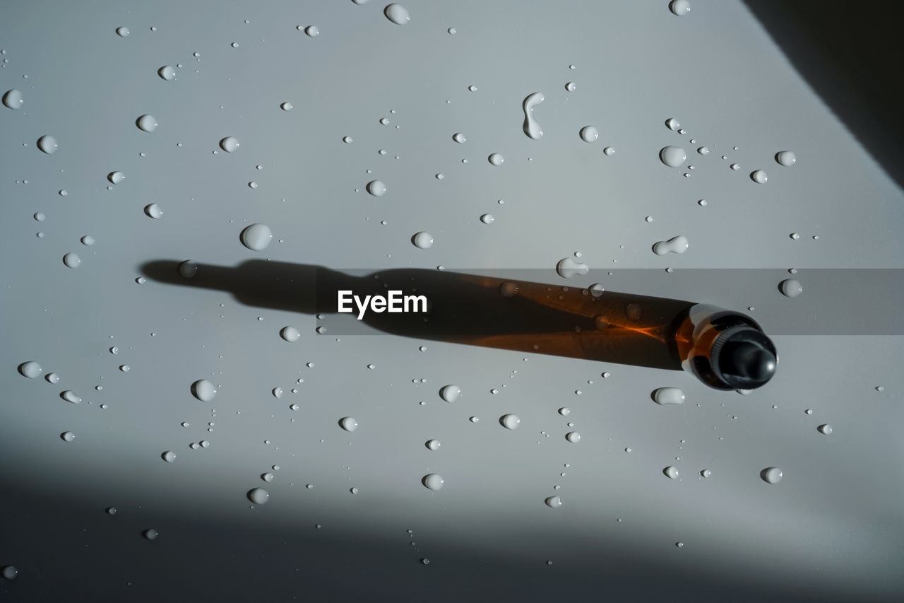 CLOSE-UP OF WATER DROPS ON GLASS WINDOW AGAINST RAINY SEASON