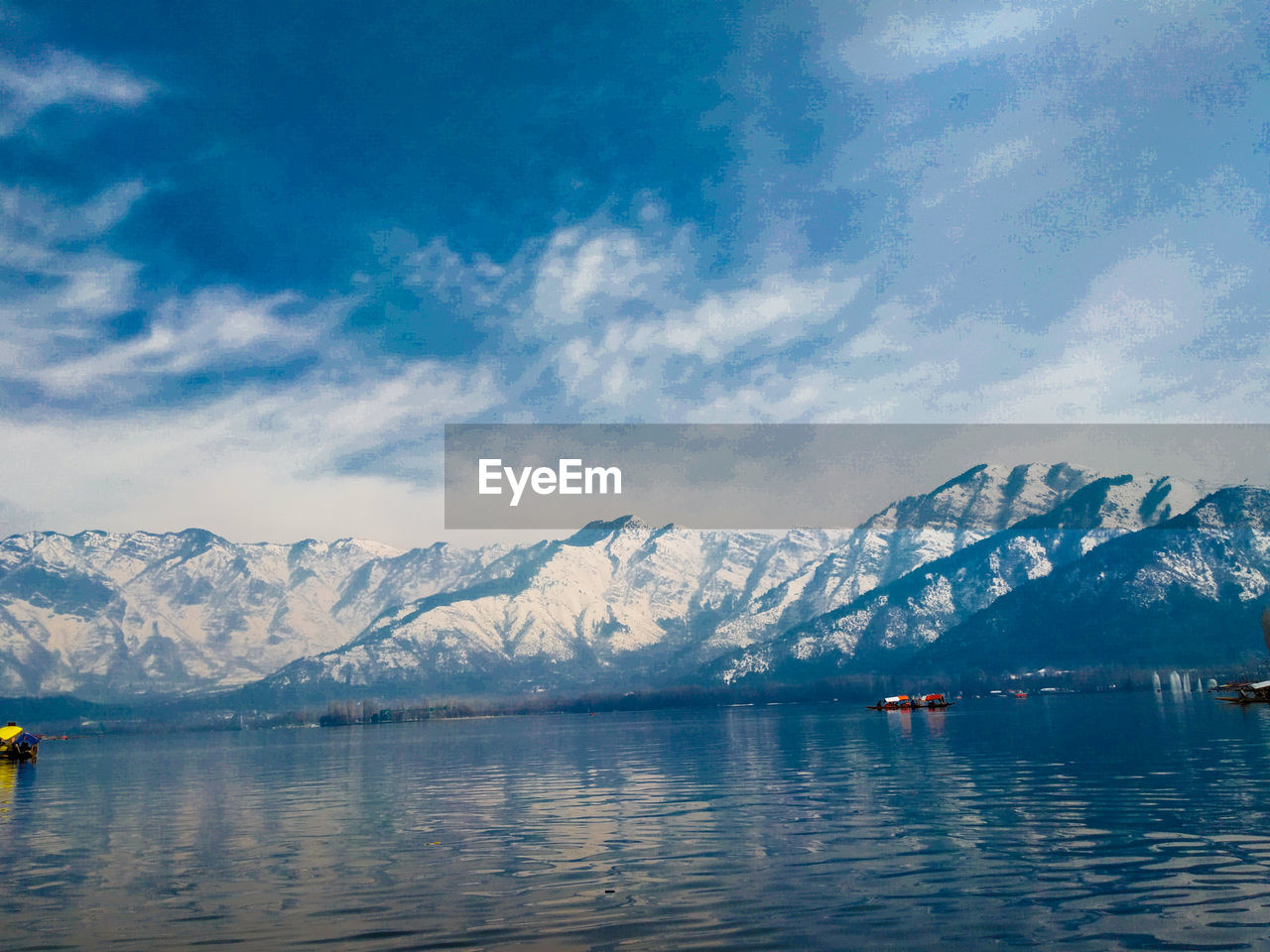 Scenic view of lake and snowcapped mountains against sky