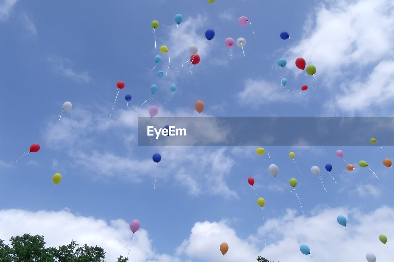 Low angle view of helium balloons in the sky