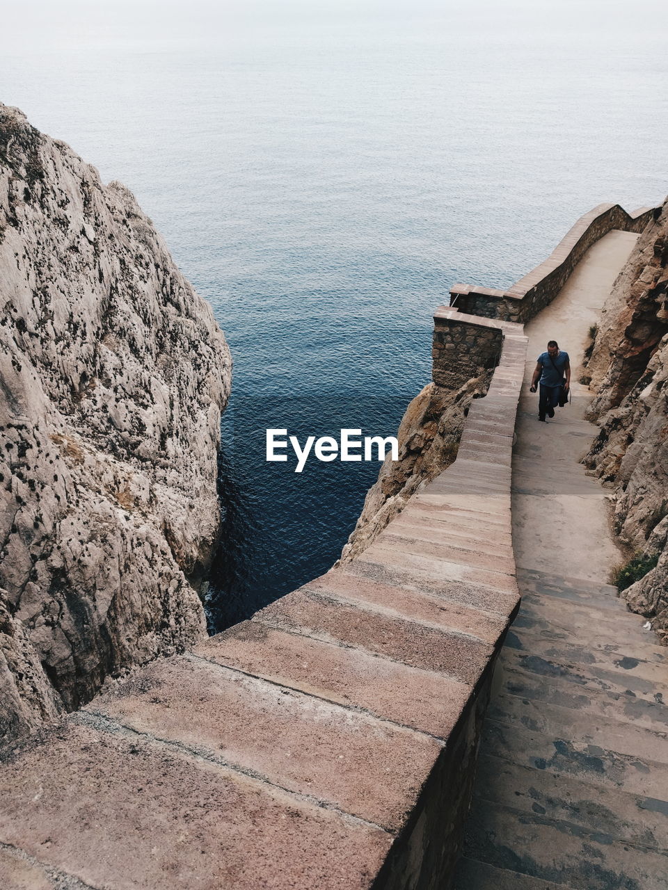 High angle view of man walking on steps by sea