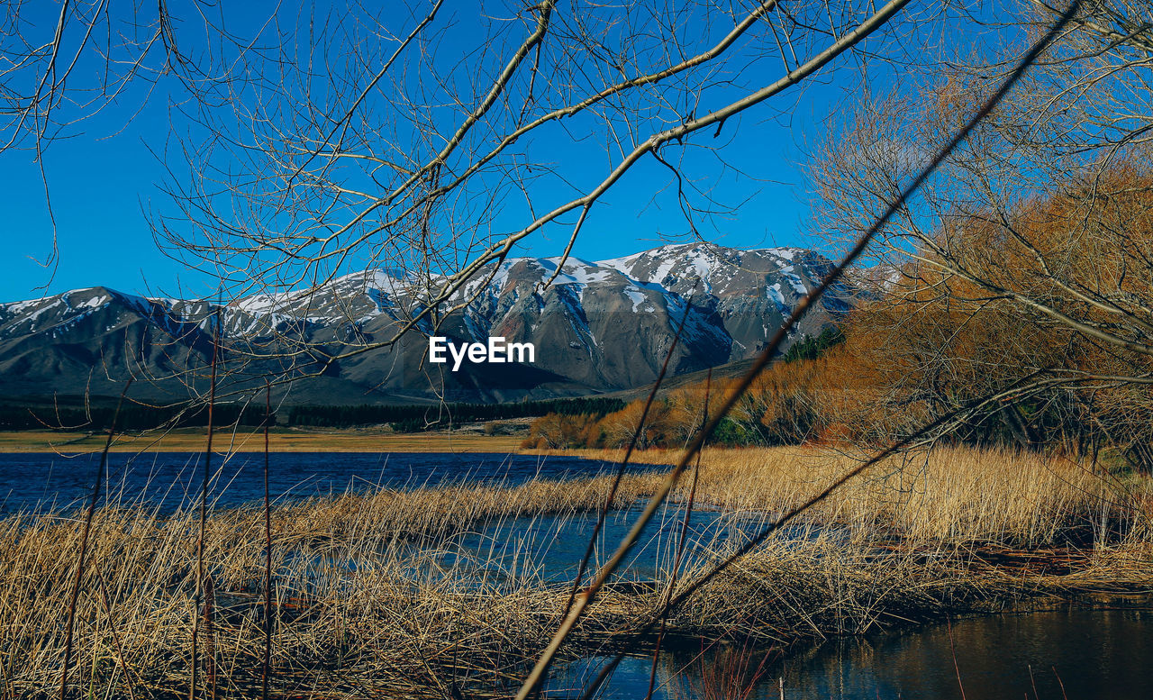 Scenic view of snowcapped mountains against clear blue sky