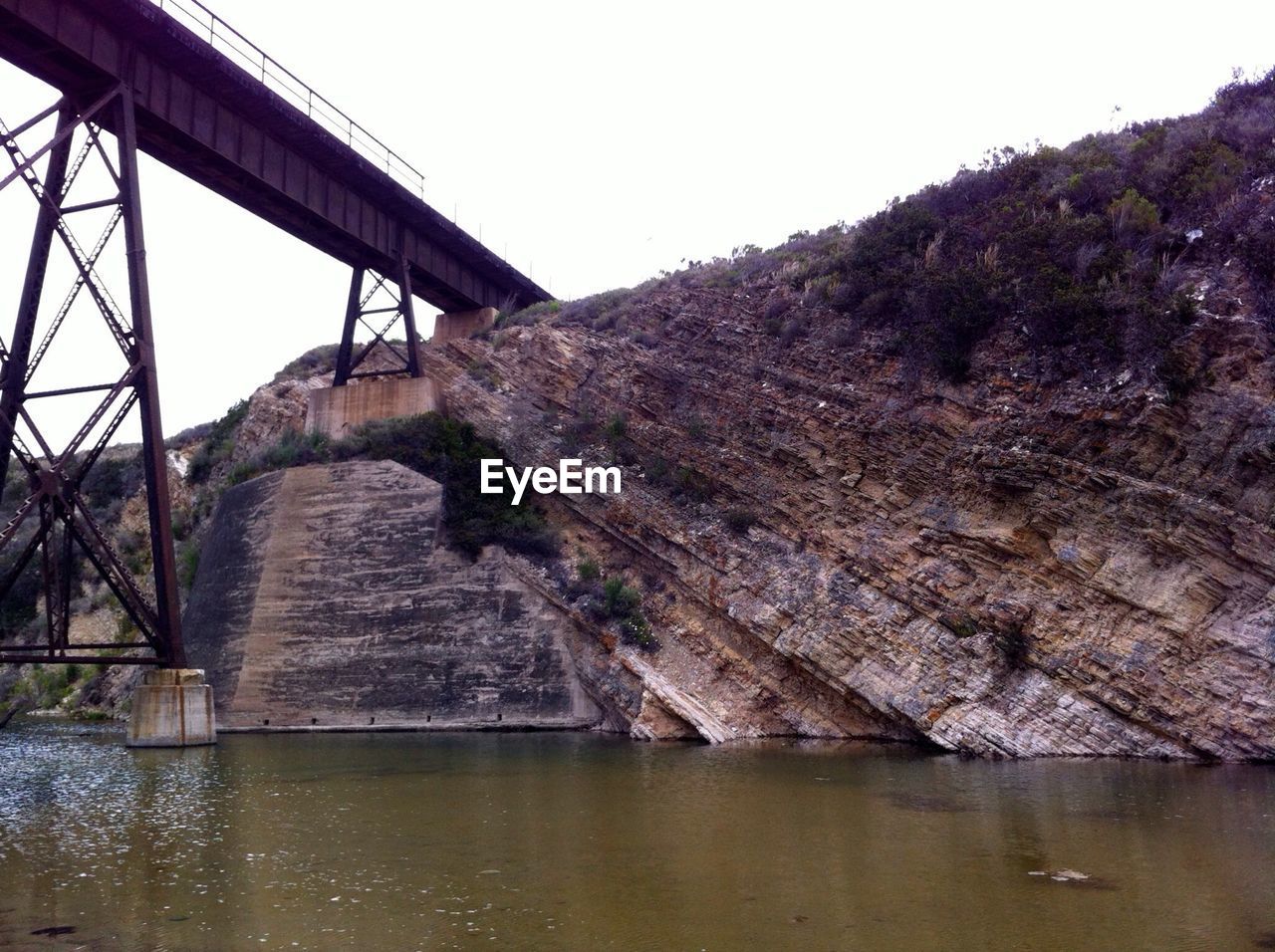 Low angle view of bridge and rock against clear sky