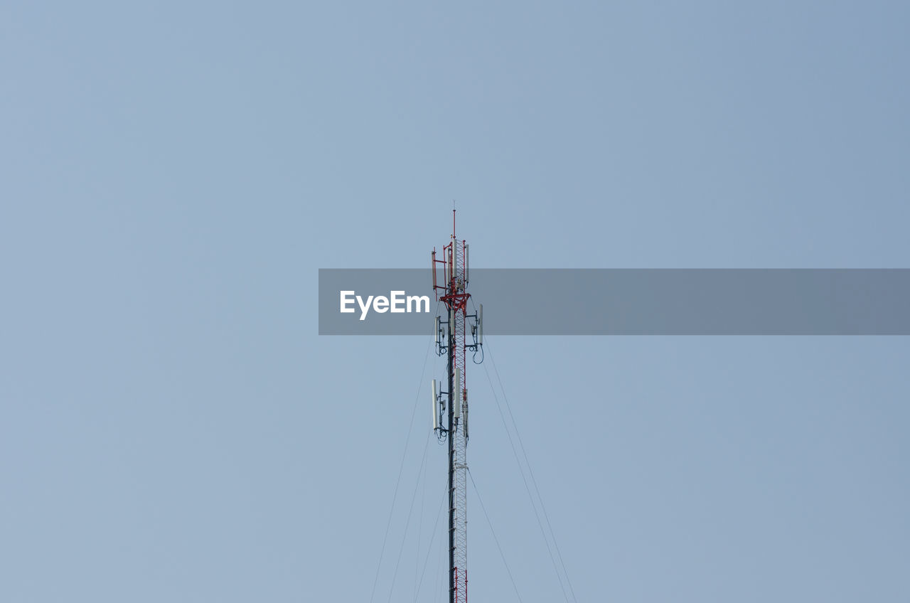 LOW ANGLE VIEW OF COMMUNICATIONS TOWER AGAINST BLUE SKY