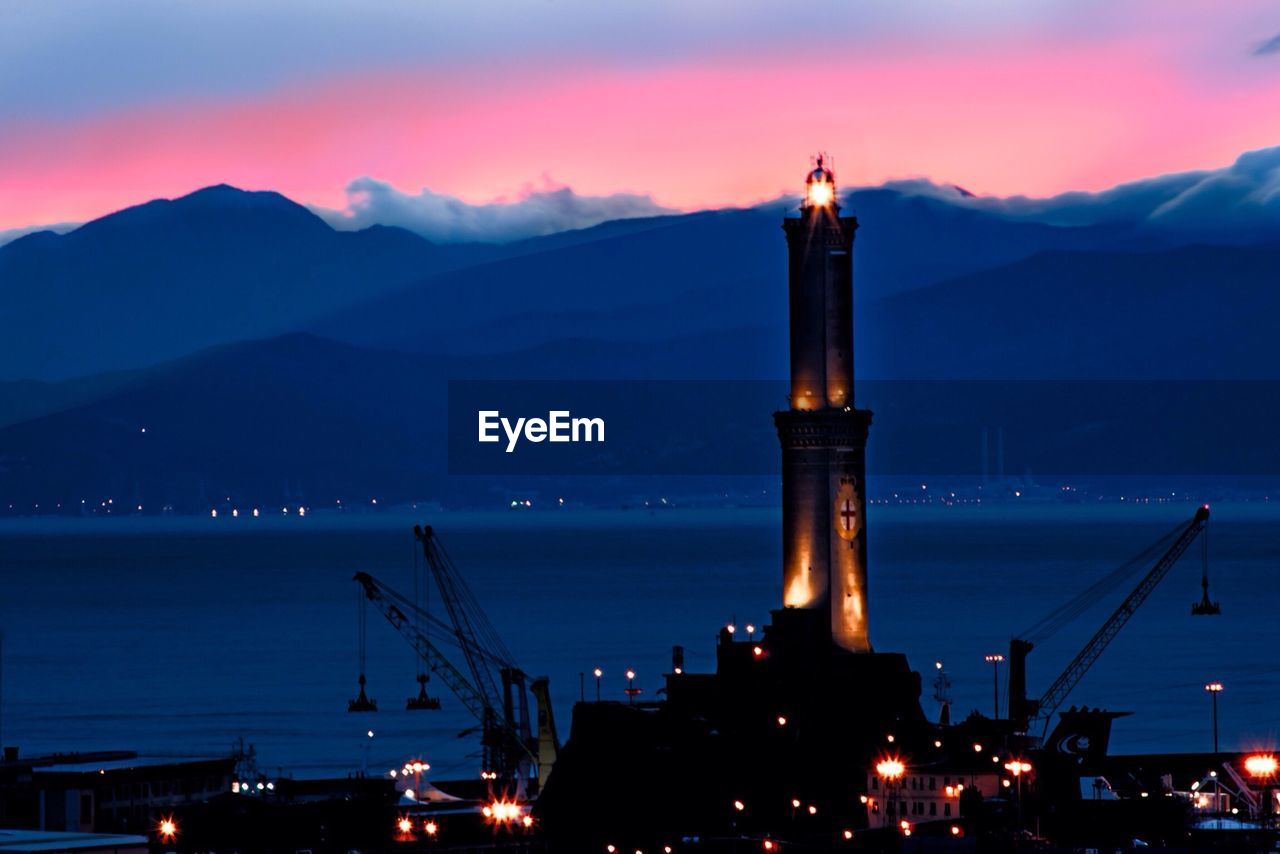 Silhouette built structures against mountain range