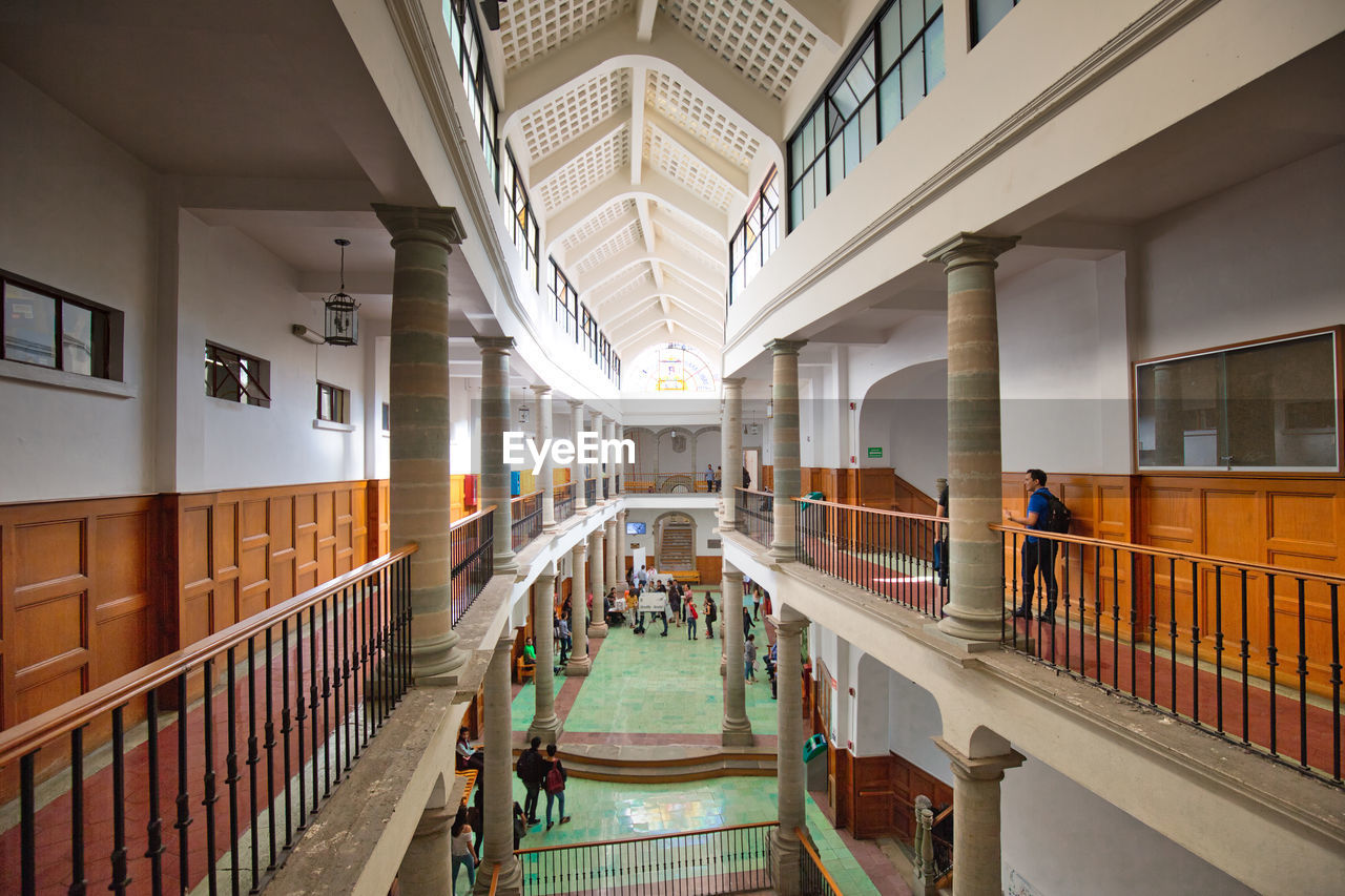 PEOPLE WALKING ON STAIRCASE IN MODERN BUILDING