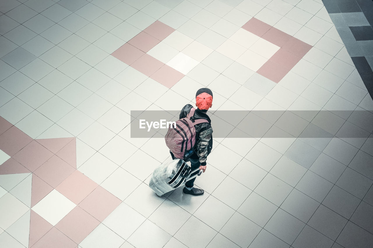 High angle view of young man walking on tiled floor